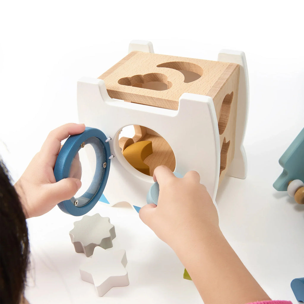 Child fitting a ring onto the wooden rocket activity centre