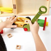 Child assembling a wooden model with the toy spanner